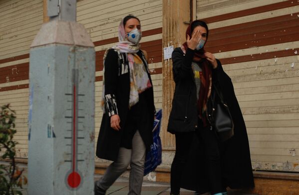 Жители Тегерана идут по одной из центральных улиц в медицинских масках - Sputnik Узбекистан