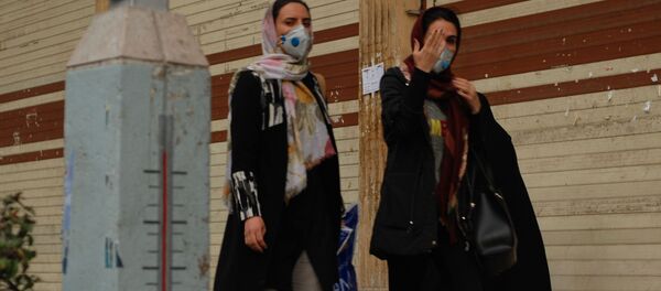Жители Тегерана идут по одной из центральных улиц в медицинских масках - Sputnik Ўзбекистон