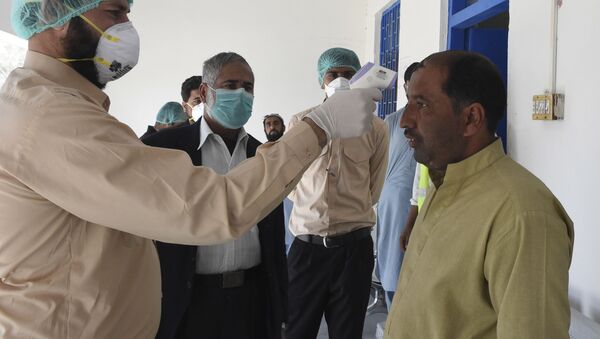 Врач проверяет температуру тела человека в городе Тафтан на пакистано-иранской границе - Sputnik Узбекистан
