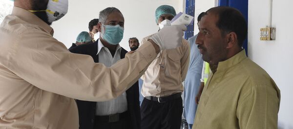 Врач проверяет температуру тела человека в городе Тафтан на пакистано-иранской границе Врач проверяет температуру тела человека в городе Тафтан на пакистано-иранской границе - Sputnik Ўзбекистон