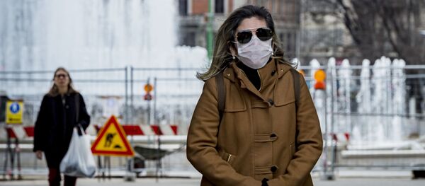 Женщина в медицинской маске в центре Милана Женщина в медицинской маске в центре Милана - Sputnik Ўзбекистон