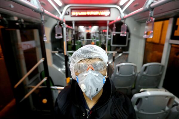 Сотрудник муниципалитета Тегерана дезинфицирует  автобус, чтобы избежать распространения коронавируса - Sputnik Ўзбекистон