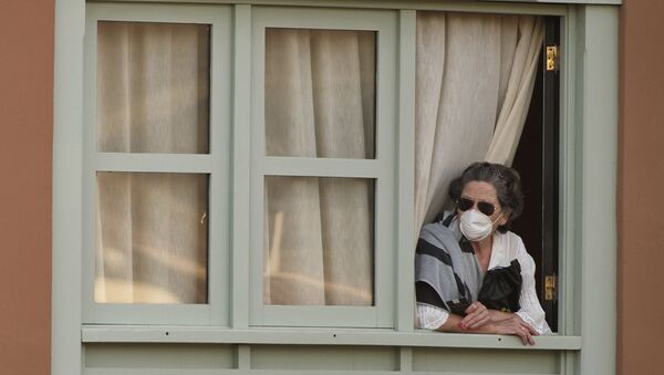 Женщина смотрит из окна Costa Adeje Palace hotel на Тенерифе - Sputnik Ўзбекистон