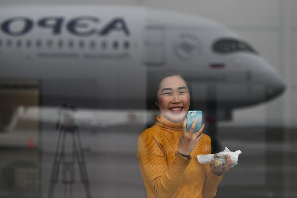 Девушка фотографирует дальнемагистральный широкофюзеляжный пассажирский самолет Airbus A350-900 авиакомпании Аэрофлот - Sputnik Ўзбекистон