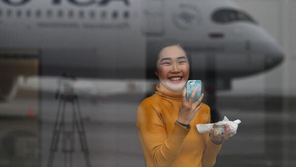 Devushka fotografiruyet dalnemagistralnыy shirokofyuzelyajnыy passajirskiy samolet Airbus A350-900 aviakompanii Aeroflot - Sputnik Oʻzbekiston