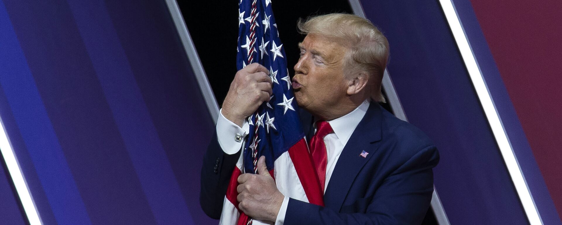 Дональд Трамп целует американский флаг - Sputnik Узбекистан, 1920, 27.02.2021