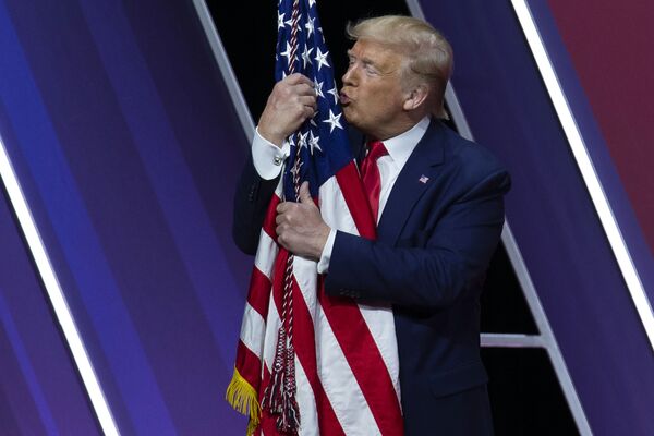 Дональд Трамп целует американский флаг - Sputnik Узбекистан