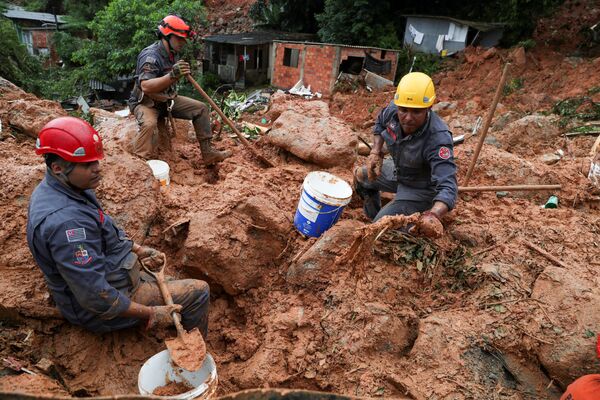 Спасатели ищут жертв оползня, вызванного проливными дождями в прибрежном городе Гуаружа, Бразилия - Sputnik Узбекистан