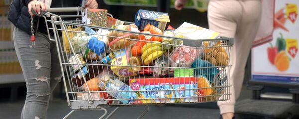 Покупатель с тележкой, наполненной продуктами в супермаркете - Sputnik Узбекистан