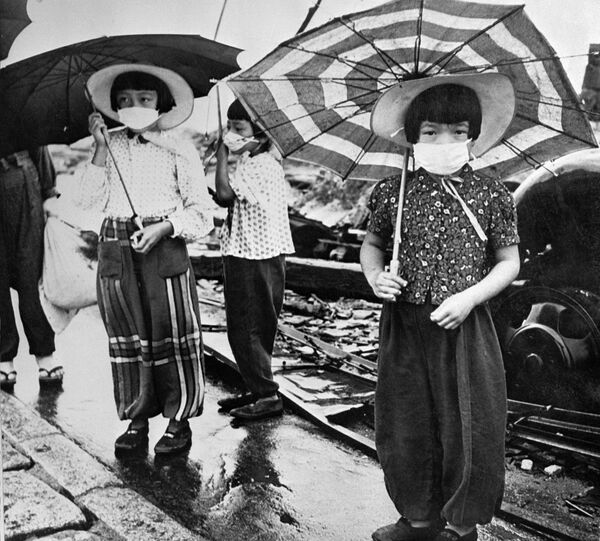 Дети в масках для защиты от облучения в разрушенной бомбардировкой Хиросиме, Япония, 1948 год - Sputnik Узбекистан