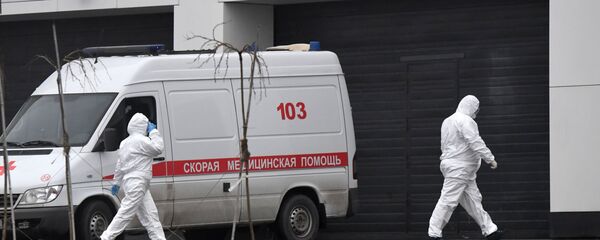 Sotrudniki skoroy pomoshi v zashitnix kostumax na territorii bolnichnogo kompleksa v Kommunarke Sotrudniki skoroy pomoshi v zashitnix kostumax na territorii bolnichnogo kompleksa v Kommunarke - Sputnik O‘zbekiston