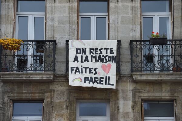 Плакат с надписью Мы остаемся дома, вы тоже оставайтесь на балконе во Франции  - Sputnik Узбекистан