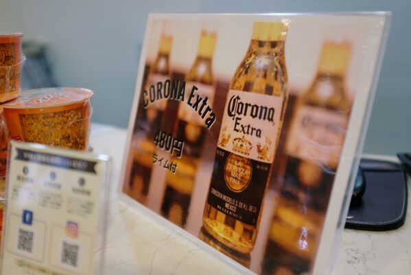 Yaponiya Osaka Corona otelida mehmonlarni rasmiylashtirish joyida Corona pivasi reklamasi - Sputnik Oʻzbekiston