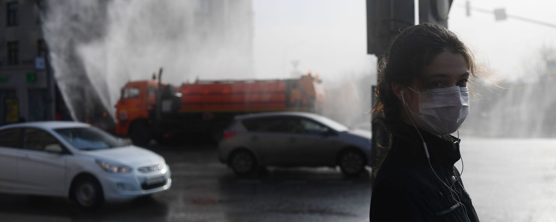 Девушка в медицинской маске стоит на переходе на Тверской улице - Sputnik Узбекистан, 1920, 07.11.2021
