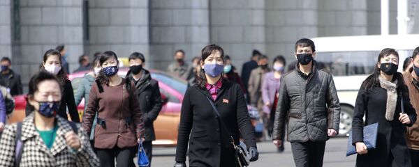 Прохожие в медицинских масках на одной из улиц Пхеньяна, Северная Корея - Sputnik Узбекистан