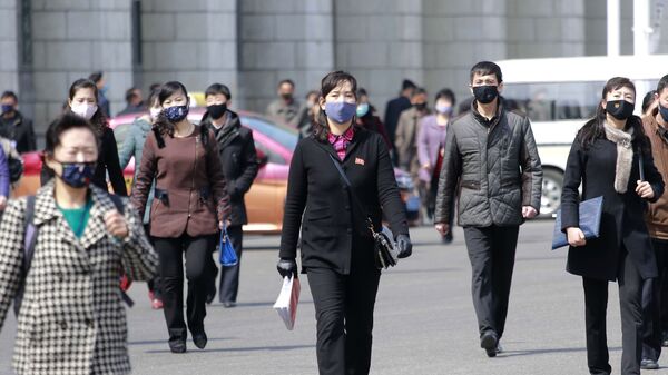 Прохожие в медицинских масках на одной из улиц Пхеньяна, Северная Корея - Sputnik Ўзбекистон