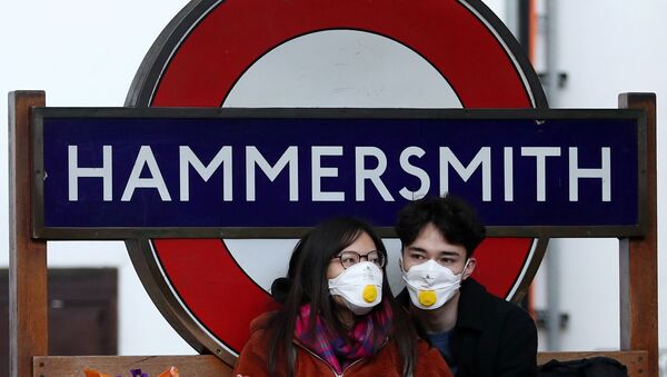 Пара в защитных масках у станции метро Hammersmith в Лондоне - Sputnik Ўзбекистон