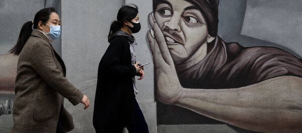 Devushki v maskax naprotiv graffiti v Uxane  - Sputnik O‘zbekiston