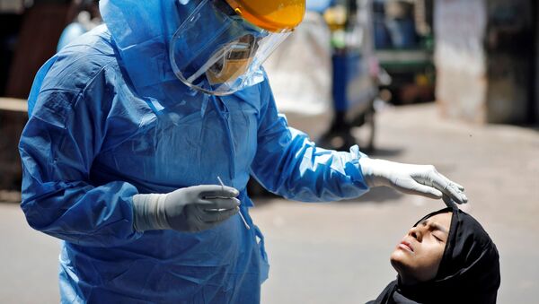 Doktor v zashitnom kostume testiruyet devushku na koronavirus v Axmedabade, Indiya - Sputnik O‘zbekiston