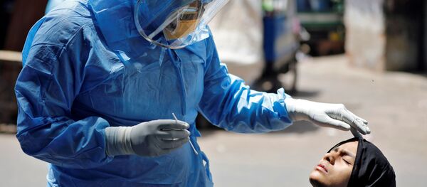 Доктор в защитном костюме тестирует девушку на коронавирус в Ахмедабаде, Индия Доктор в защитном костюме тестирует девушку на коронавирус в Ахмедабаде, Индия - Sputnik Ўзбекистон