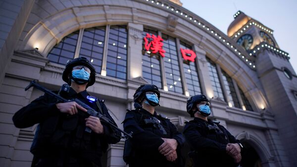 Сотрудники службы безопасности в защитных масках у железнодорожного вокзала Ханькоу в Ухане, Китай - Sputnik Ўзбекистон