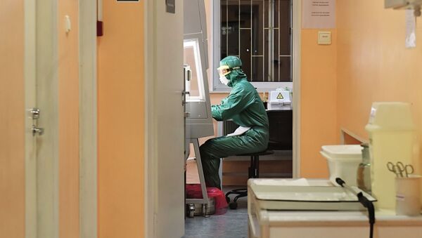 Сотрудник лаборатории во время тестирования проб на коронавирус - Sputnik Узбекистан