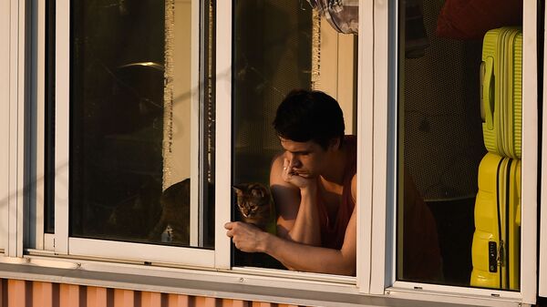 Молодой человек с кошкой на балконе многоквартирного дома в Москве - Sputnik Узбекистан