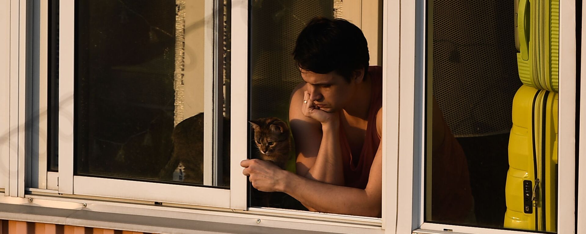 Молодой человек с кошкой на балконе многоквартирного дома в Москве - Sputnik Узбекистан, 1920, 20.11.2021