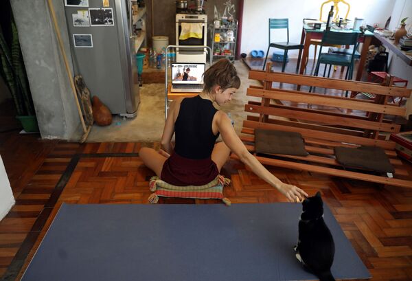 Инструктор по йоге со своей кошкой во время онлайн-урока у себя дома в Рио-де-Жанейро, Бразилия - Sputnik Узбекистан
