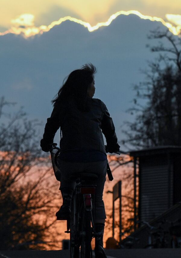 Велосипедистка на фоне заката в Берлине, Германия - Sputnik Узбекистан