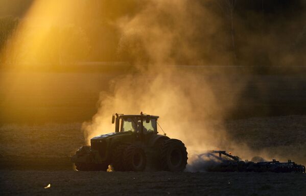 Трактор в поле на фоне заката в Минске, Белоруссия - Sputnik Узбекистан