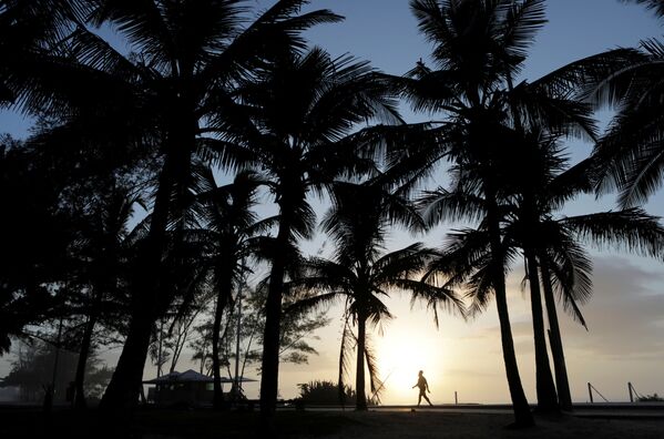 Мужчина гуляет во время заката на пляже в Рио-де-Жанейро, Бразилия - Sputnik Узбекистан