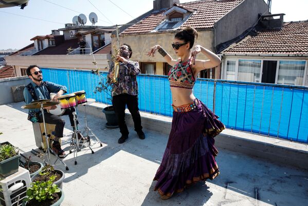 Танцовщица выступает на террасе дома в сопровождении музыкантов в Стамбуле, Турция - Sputnik Узбекистан