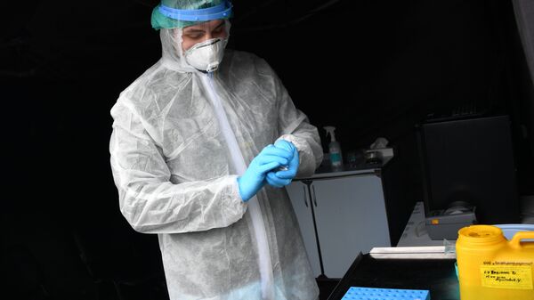 Сотрудник лаборатории упаковывает биоматериал, собранный для анализа на коронавирус - Sputnik Ўзбекистон