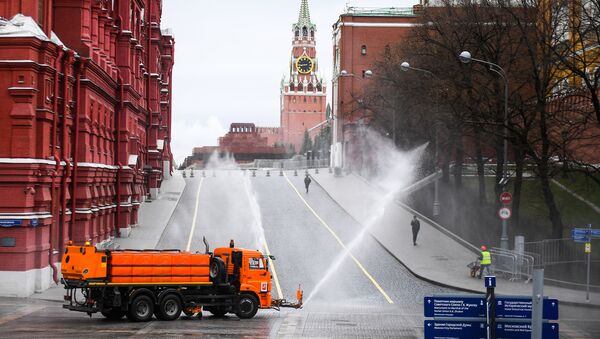 Автомобиль коммунальных служб дезинфицирует дороги и тротуары у Красной площади в Москве - Sputnik Узбекистан