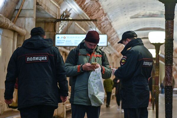 Полицейские и пассажир на станции метро Новокузнецкая в Москве - Sputnik Узбекистан