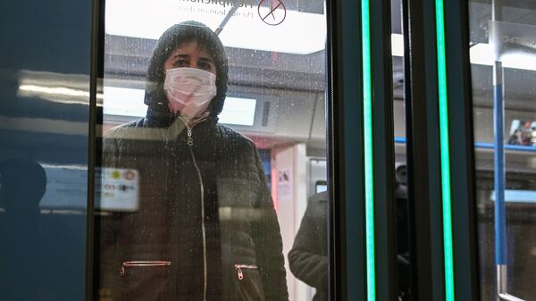 Женщина в защитной маске в вагоне поезда на станции метро Новокузнецкая в Москве - Sputnik Ўзбекистон