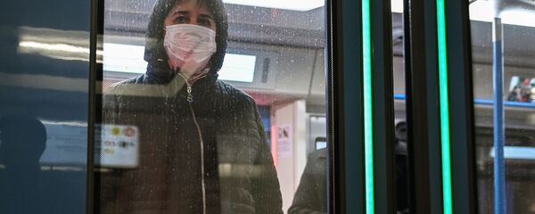 Женщина в защитной маске в вагоне поезда на станции метро Новокузнецкая в Москве Женщина в защитной маске в вагоне поезда на станции метро Новокузнецкая в Москве - Sputnik Ўзбекистон