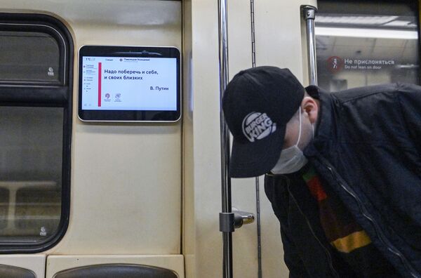 Мужчина в защитной маске в вагоне поезда Московского метрополитена - Sputnik Узбекистан