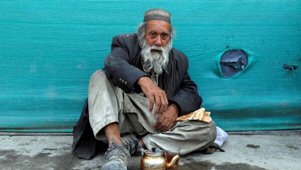 Бездомный мужчина пьет чай в придорожном чайном магазине в Кабуле, Афганистан - Sputnik Ўзбекистон
