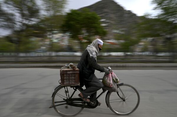 Mujchina v zashitnoy maske yedet na velosipede po Kabulu, Afganistan - Sputnik O‘zbekiston