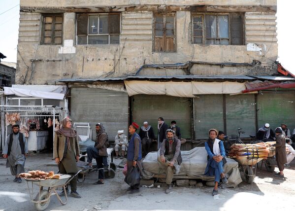 Рабочие на фоне закрытого из-за коронавируса рынка в Кабуле, Афганистан - Sputnik Ўзбекистон