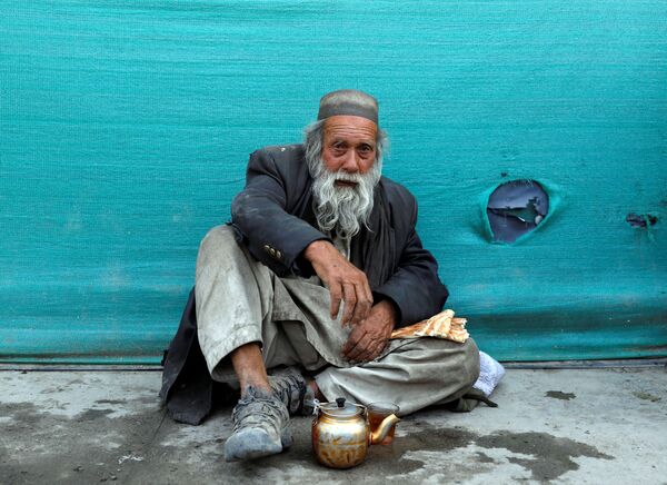 Бездомный мужчина пьет чай в придорожном чайном магазине в Кабуле, Афганистан - Sputnik Ўзбекистон
