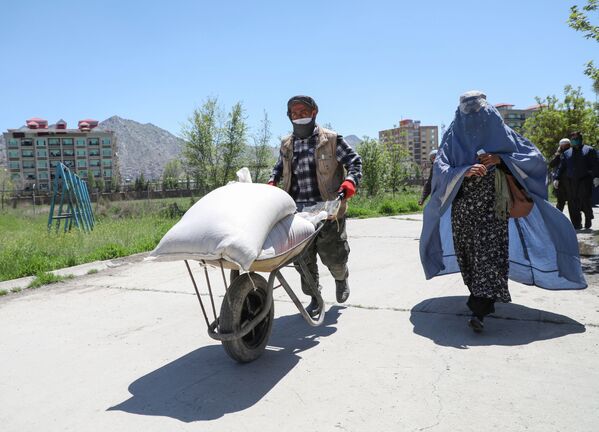 Afganes vezet na telege odin iz meshkov s pshenitsey, pojertvovannix pravitelstvom Afganistana v kachestve pomoshi naseleniyu, Kabul - Sputnik O‘zbekiston