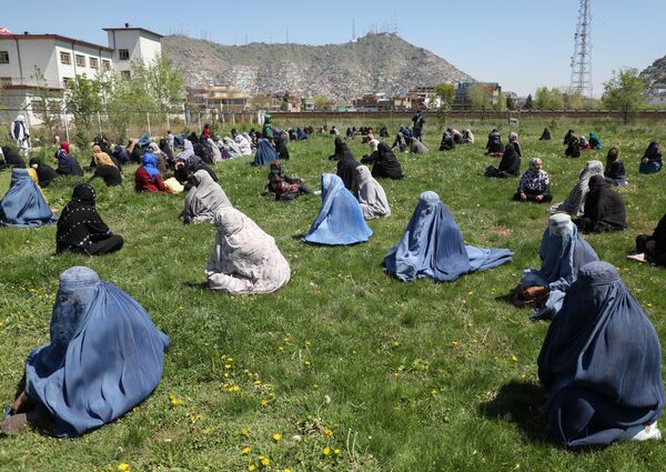 Женщины ждут бесплатное продовольствие на газоне в Кабуле, Афганистан  - Sputnik Ўзбекистон