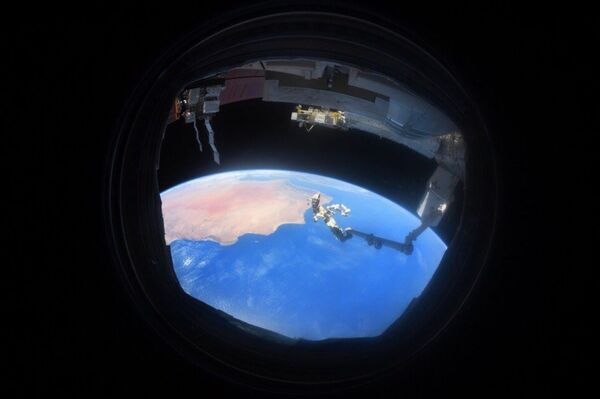Снимок Земли через иллюминатор, сделанный на МКС космонавтом Антоном Шкаплеровым - Sputnik Узбекистан