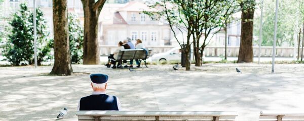 Пожилой мужчина сидит на скамейке в парке - Sputnik Узбекистан