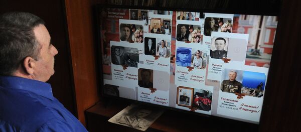 Мужчина смотрит онлайн-трансляцию акции Бессмертный полк Мужчина смотрит онлайн-трансляцию акции Бессмертный полк - Sputnik Узбекистан