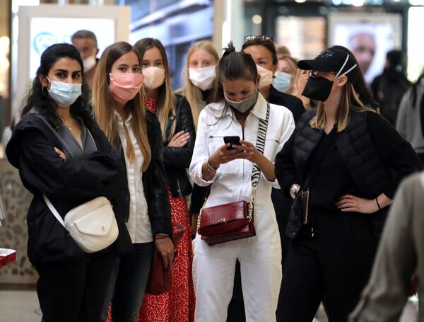 Девушки в масках во время открытия магазина после облегчения карантинных мер во Франции  - Sputnik Узбекистан