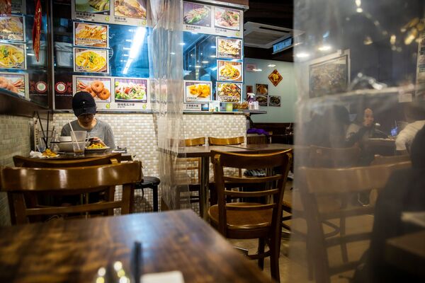 Посетитель ресторана, разделенного пластиковыми шторками в Гонконге - Sputnik Узбекистан